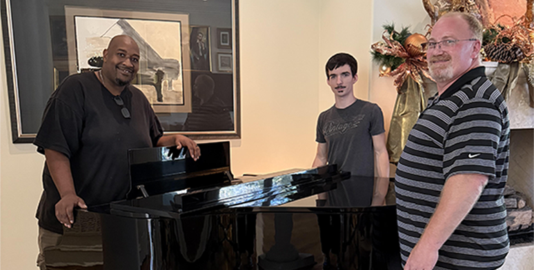 All The Right Moves team around a grand piano